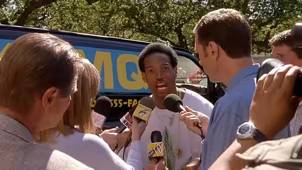 Ray (Shawn Wayans) answers reporters’ questions as microphones crowd around him