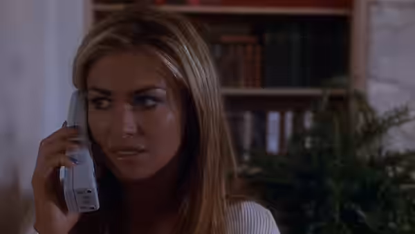 Buffy (Shannon Elizabeth) holds a cordless phone and looks anxiously to the side
