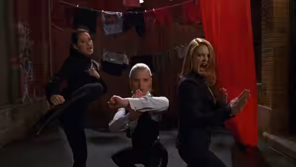 Alex Munday (Lucy Liu), Natalie Cook (Cameron Diaz) and Dylan Sanders (Drew Barrymore) strike martial arts poses in an alley