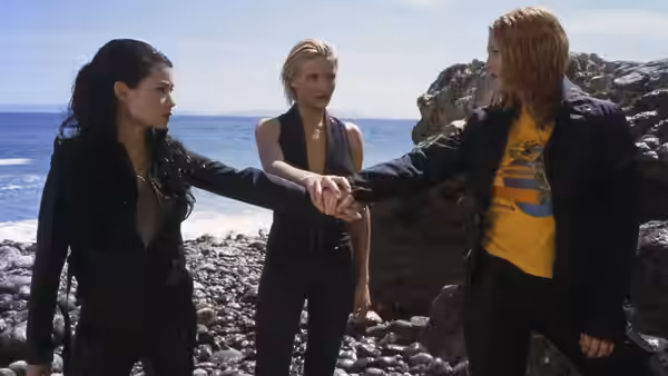 Alex Munday (Lucy Liu), Natalie Cook (Cameron Diaz) and Dylan Sanders (Drew Barrymore) join hands on a rocky beach