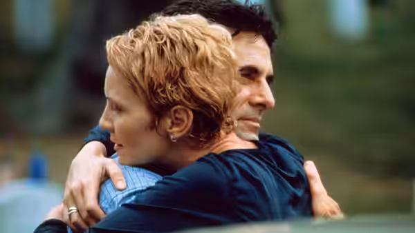 Laine Hanson (Joan Allen) embraces a man outdoors