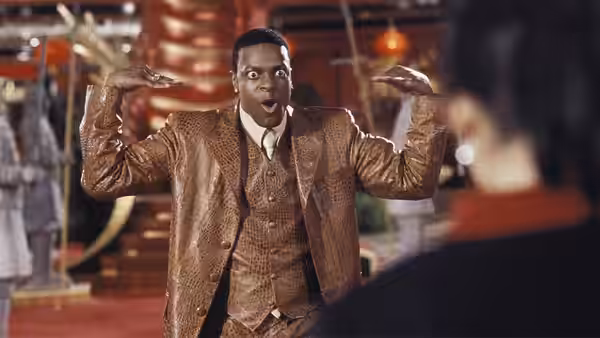 Carter gestures in a gold suit inside a casino