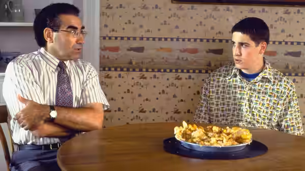 Jim Levenstein sits at a table with his father, facing a plate of food