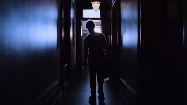 David Aames (Tom Cruise) walks down a dark hallway toward an open doorway