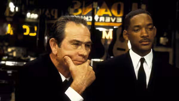 Kay (Tommy Lee Jones) rests his chin on his hand beside Jay (Will Smith)
