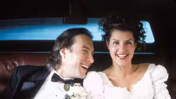 Toula Portokalos (Nia Vardalos) and Ian Miller (John Corbett) laugh together in a car