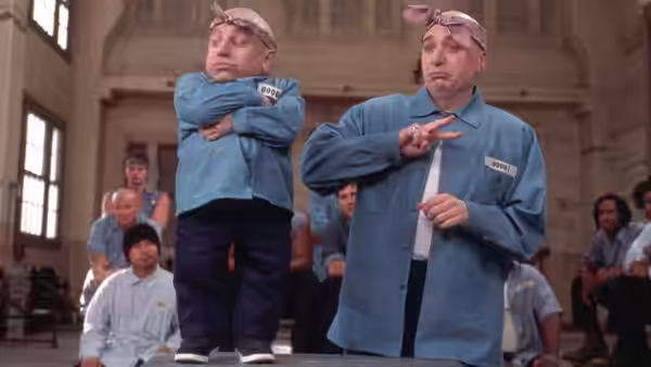 Mini-Me (Verne Troyer) and Fat Bastard (Mike Myers) pose in prison uniforms before inmates