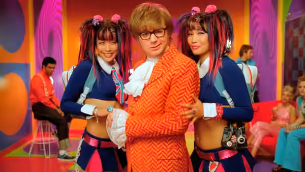 Austin Powers (Mike Myers) poses between Fook Mi and Fook Yu in a colorful room