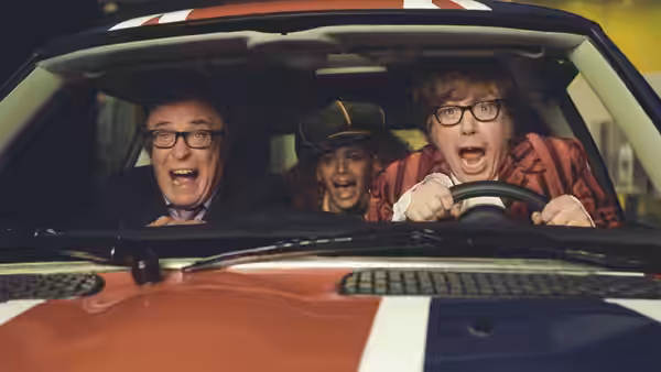 Austin Powers (Mike Myers) drives a red convertible with Nigel Powers and Foxxy Cleopatra