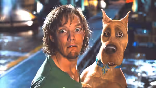 Shaggy (Matthew Lillard) and Scooby-Doo stare wide-eyed in a dim interior