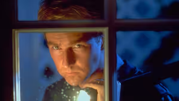 Will Graham (Edward Norton) peers through a window, holding a light beneath his face