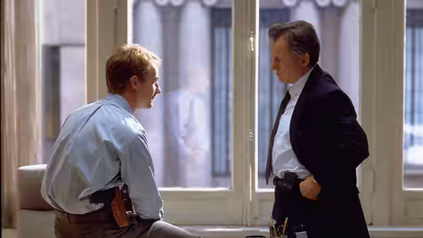 Will Graham (Edward Norton) sits by a window speaking with Jack Crawford (Harvey Keitel)