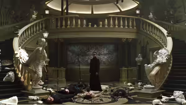 Agent Smith (Hugo Weaving) stands among fallen fighters in a grand hall