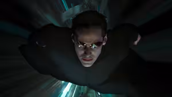 Neo (Keanu Reeves) flies through a dark, illuminated tunnel