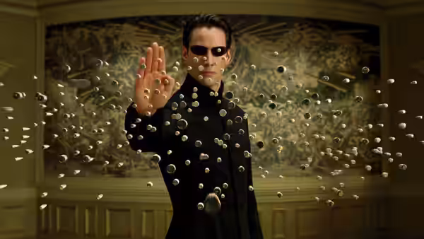Neo (Keanu Reeves) holds bullets suspended before him in an ornate room