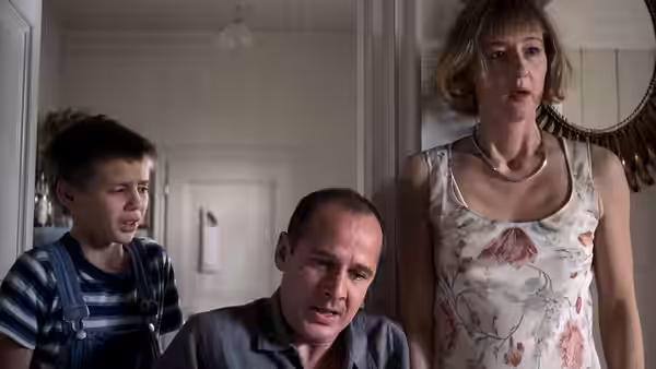Georg (Ulrich Mühe) Anna (Susanne Lothar) and Georgie (Stefan Clapczynski) stand together in a hallway
