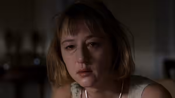 Anna (Susanne Lothar) sits with a tear-streaked face and swollen eyes in dim light