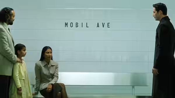 Neo faces a seated woman and a family in the Mobil Ave station