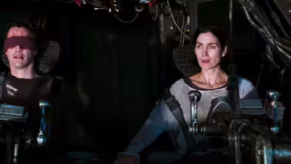 Trinity pilots the ship beside blindfolded Bane in the cockpit