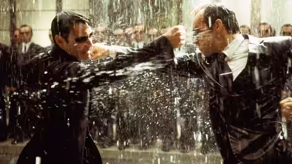 Neo and Agent Smith trade punches in a rain-soaked street