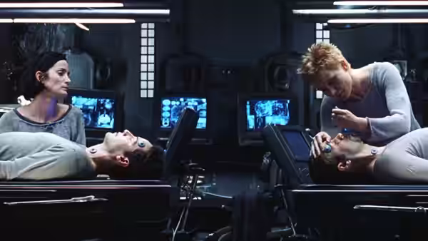 Trinity and a crew member tend to Neo and another man in medical pods