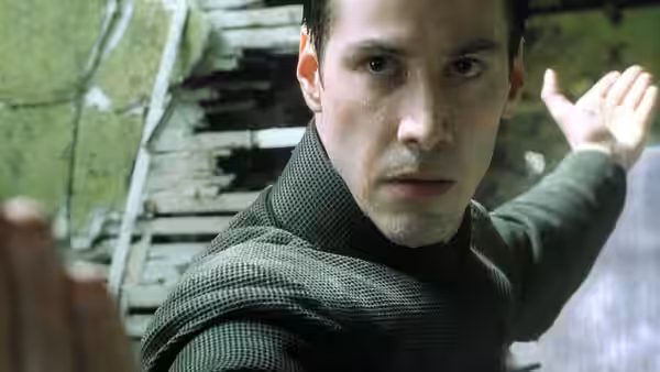 Neo raises an arm to strike amid the rubble