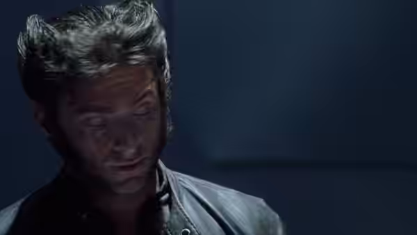 Wolverine (Hugh Jackman) looks downward in a dimly lit room