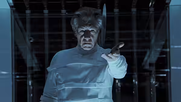 Professor Xavier (Patrick Stewart) reaches forward inside a metal-framed chamber