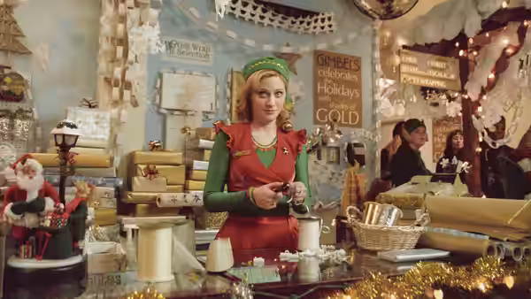 Jovie (Zooey Deschanel) works at the gift-wrapping counter in Gimbels