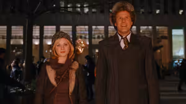 Jovie (Zooey Deschanel) and Walter (James Caan) stand together inside a crowded building