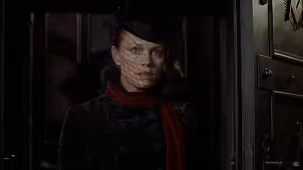Mina Harker (Peta Wilson) peers through a doorway beneath a veiled hat
