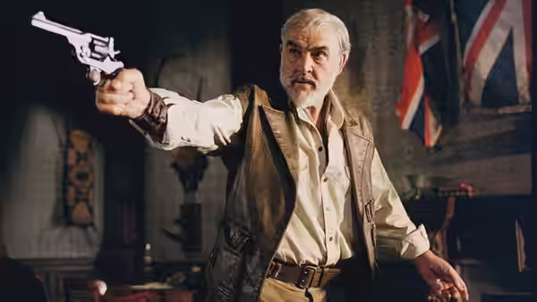 Allan Quatermain (Sean Connery) aims a revolver inside a room