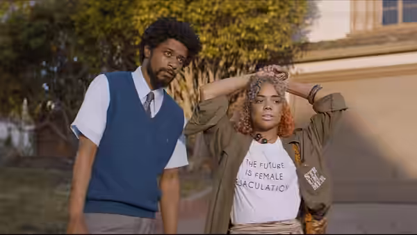 LaKeith Stanfield watches Tessa Thompson adjust her hair outside