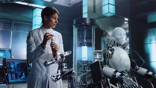 Susan Calvin (Bridget Moynahan) examines a small device beside a seated robot in the laboratory