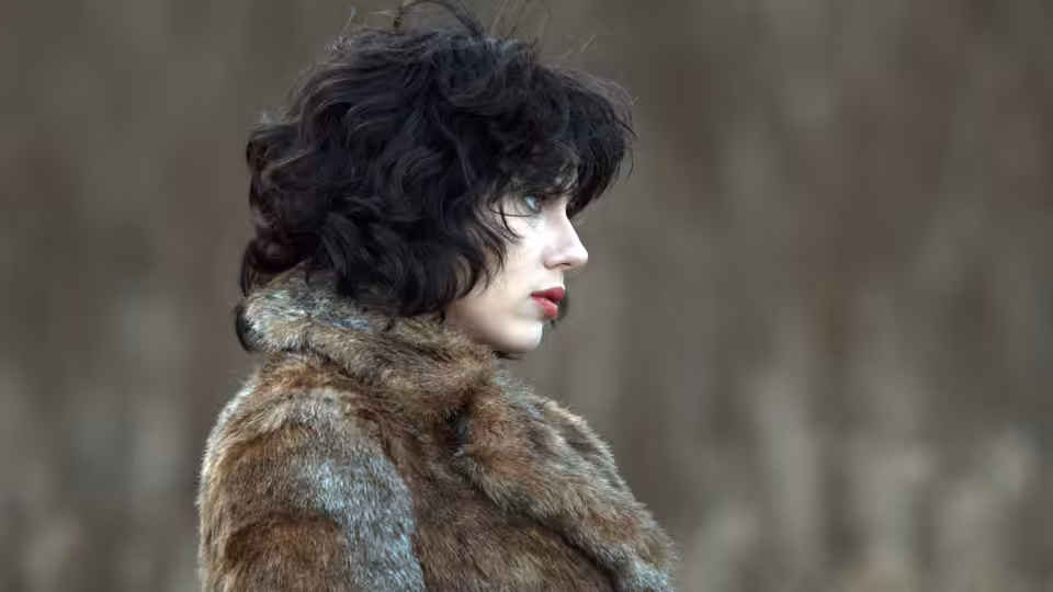 Scarlett Johansson in profile wearing a brown fur coat outdoors