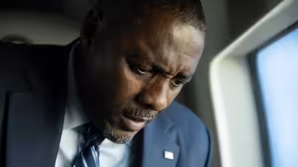 POTUS (Idris Elba) with a concerned expression inside a vehicle
