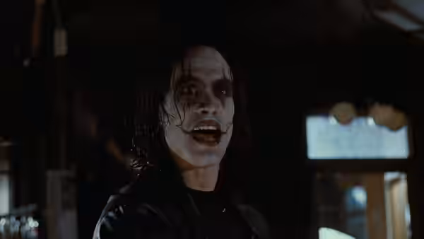Eric (Brandon Lee) speaks inside a dark room