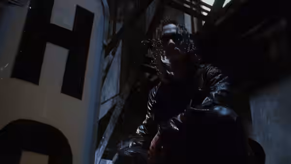 Eric (Brandon Lee) crouches on a metal structure above a dark building interior