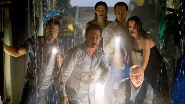 Robert Ramsey (Kurt Russell) and other passengers search a flooded corridor with flashlights