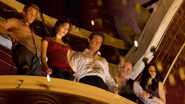 Robert Ramsey (Kurt Russell) and passengers look down from an interior balcony