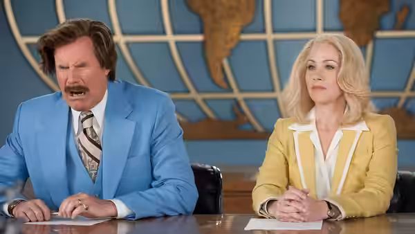 Ron Burgundy (Will Ferrell) and Veronica Corningstone (Christina Applegate) sit at a news desk