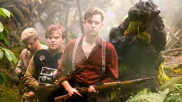 Jack Driscoll carries a rifle beside Carl Denham and a film camera in the jungle