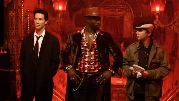 John Constantine, Midnite, and Chas Kramer stand together in a red-lit club