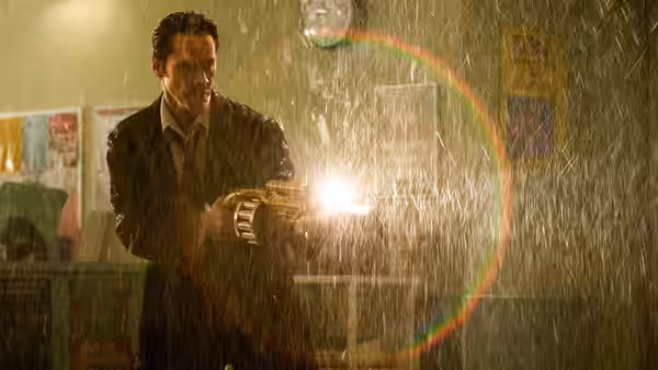 John Constantine (Keanu Reeves) fires a weapon through a rain-soaked room