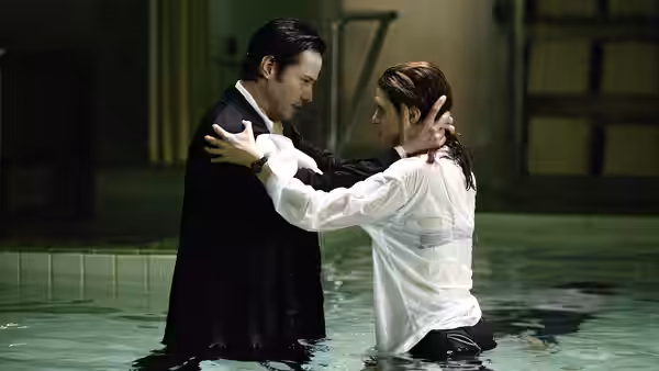 John Constantine and Angela Dodson hold each other in a flooded room