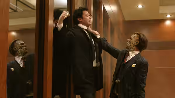 John Constantine (Keanu Reeves) is held against a doorway by two decaying men