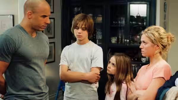 Shane Wolfe (Vin Diesel) talks with three teenagers in a home