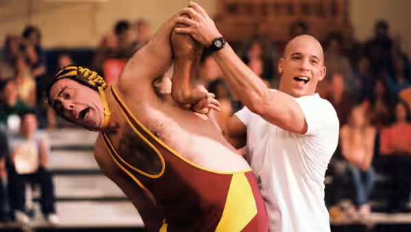 Shane Wolfe (Vin Diesel) holds a wrestler's leg during a match before a crowd