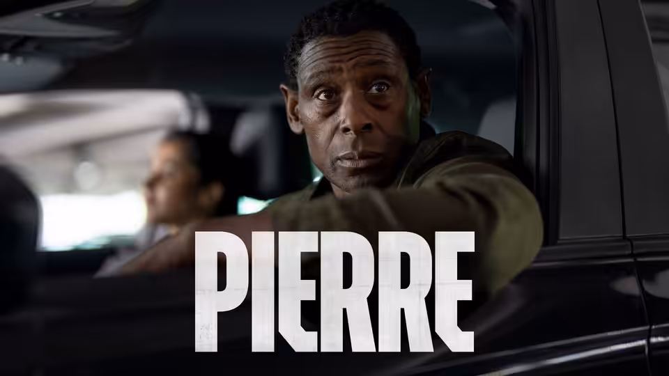 Pierre (David Harewood) sits in a car, turning to look behind him