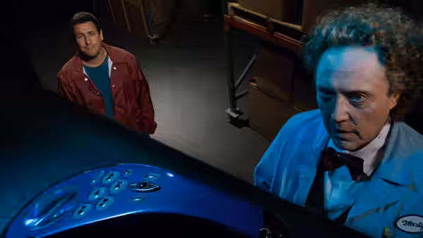 Morty (Christopher Walken) examines a control console while Michael Newman (Adam Sandler) stands behind him